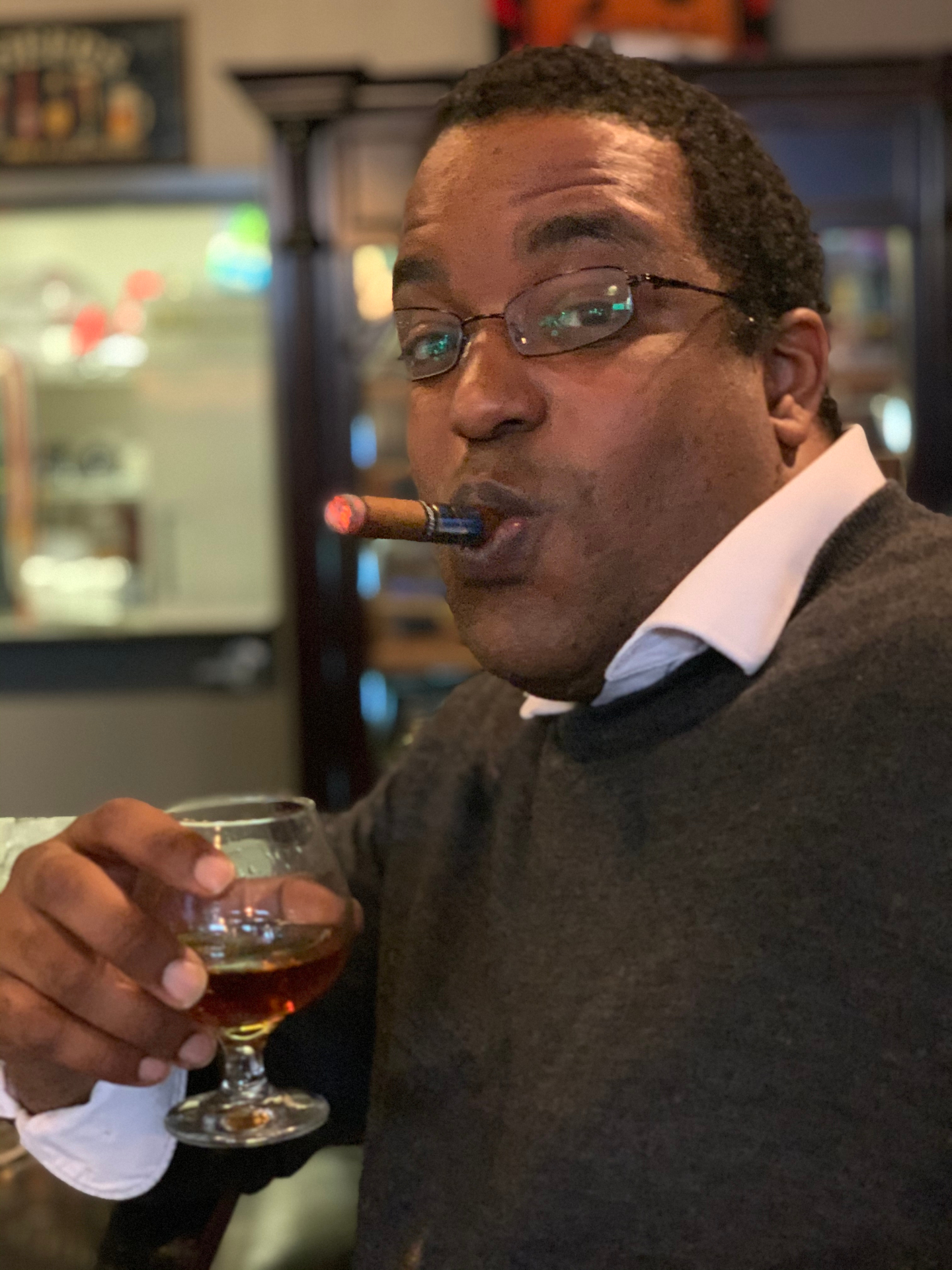 Ammanuel Santa Anna at the bar — cigar lit, brandy in hand, mid-thesis.